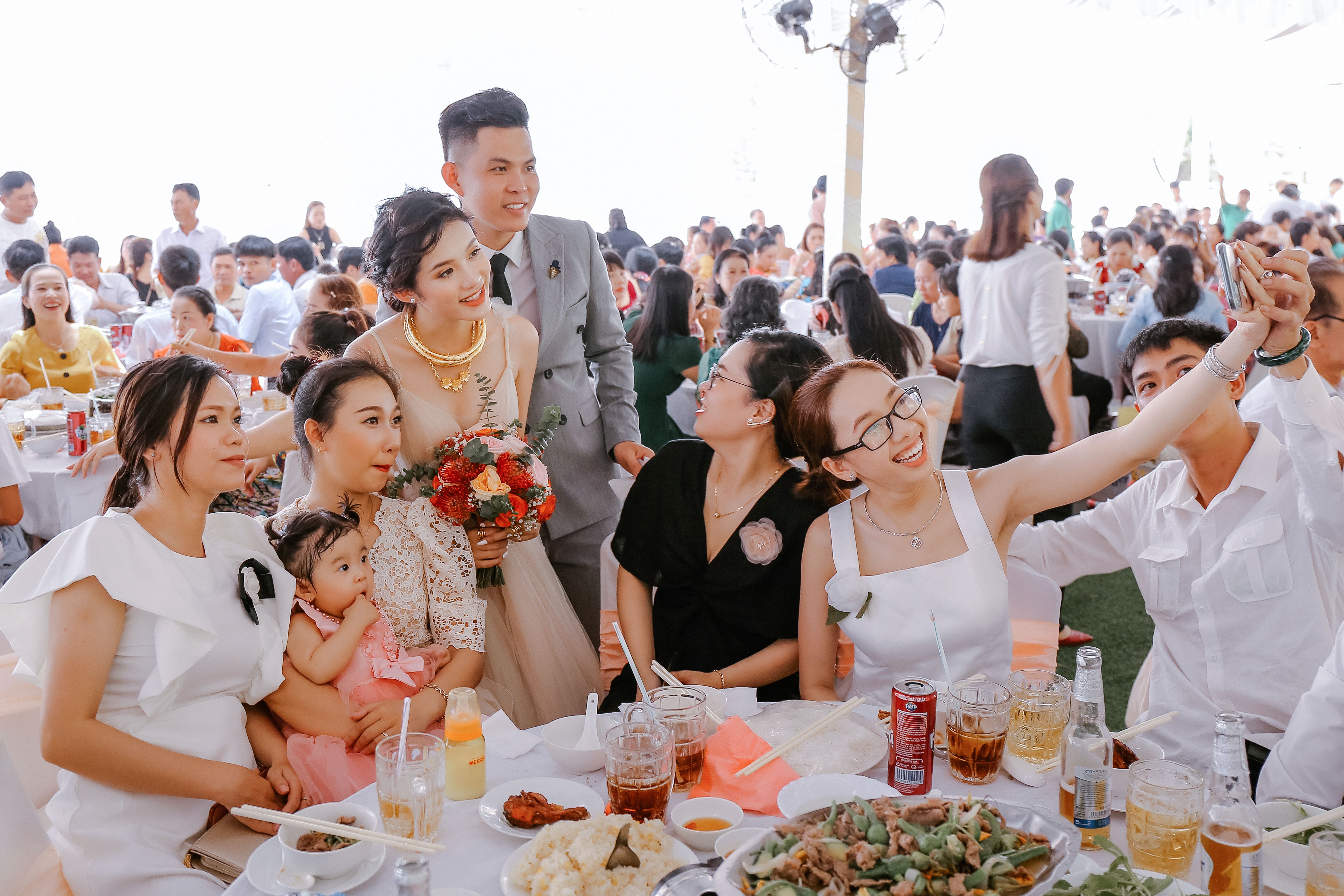 Wedding guests taking a selfie with the newlyweds during a celebration